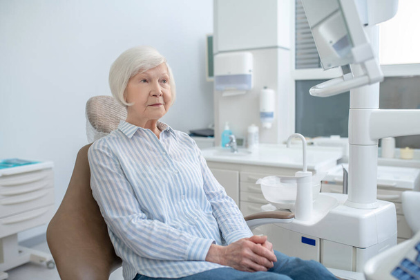 Femme âgée assise au cabinet des dentistes et attendant le médecin - Photo, image