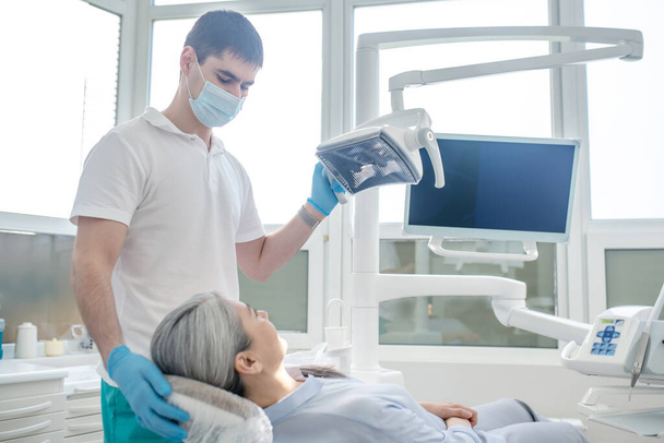 Männlicher Arzt und eine Patientin in der Zahnarztpraxis - Foto, Bild