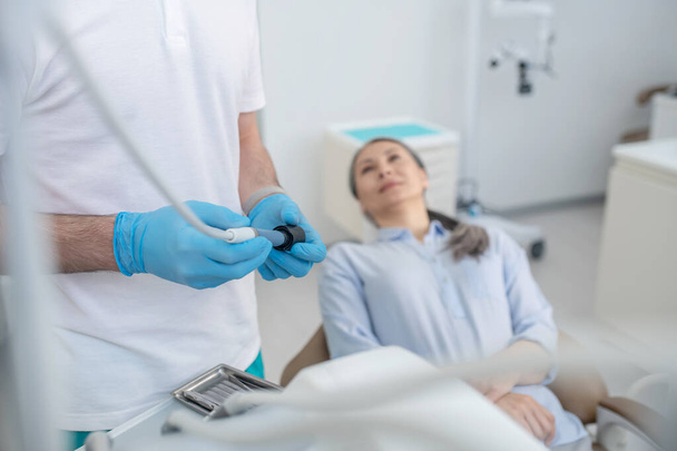 Orvos és egy női beteg a fogorvosi rendelőben a fogak helyreállítása előtt. - Fotó, kép