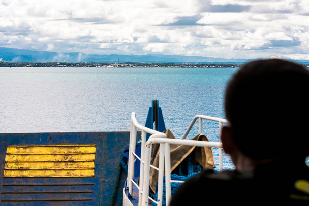 男は目的地の港の近くでローロ船として待っています。フィリピンのボホールのUbayで. - 写真・画像
