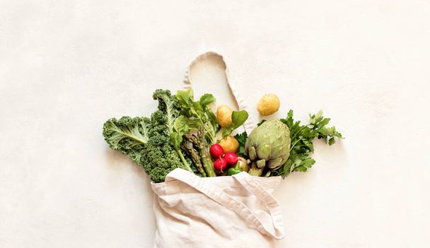 Szoros rálátás a friss szezonális zöldségekkel rendelkező textilökotáskára, fenntartható táplálkozás koncepció - Fotó, kép