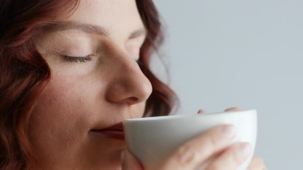Close up girl boit du café parfumé. Elle aime son cappuccino du matin ou son blanc plat. Concept de mode de vie sain - Séquence, vidéo