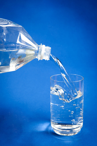 Pouring water from plastic bottle into glass - Foto, imagen
