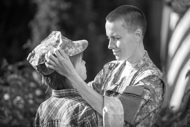 Happy reunion of female mother soldier with family son outdoors - Foto, Imagen
