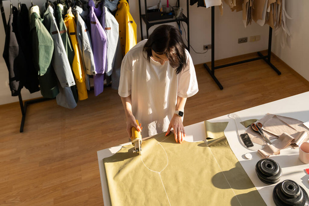 縫製と切断プロセス:アトリエスタジオでコレクションのための生地のパターンとドレスメーカーの仕事 - 写真・画像