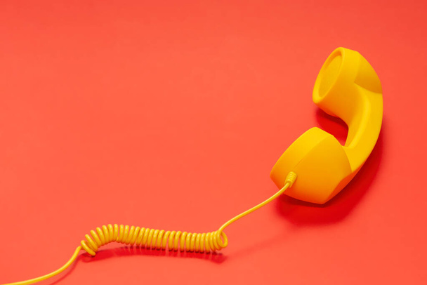 Yellow handset on red background.  - Photo, Image