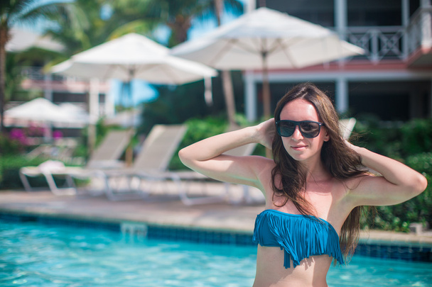 Young beautiful woman enjoying vacation in the pool - Photo, Image