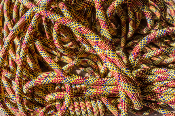 Разноцветные скалолазающие канаты в пучках. Макро детали нейлоновой веревки. Фон карусели для скалолазания. - Фото, изображение