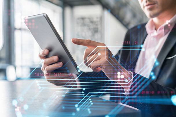 Businessman in suit using tablet device to optimize development by implying new technologies in business process. Interconnections and hi tech hologram over modern panoramic office background - Fotoğraf, Görsel