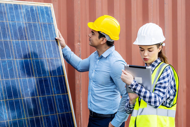 Inżynierowie energii męskiej wraz ze swoją koleżanką omawiają nowy projekt dotyczący inwestycji w instalację ogniw słonecznych poza budynkiem lub fabryką przemysłową - Zdjęcie, obraz