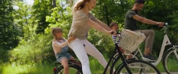 Video van speelse familie die plezier heeft op een fiets in het bos. Opgenomen met RED helium camera in 8K. - Video