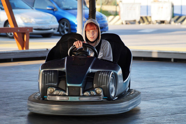 adolescente chica cabalgando un kart eléctrico en un parque de atracciones. - Foto, imagen