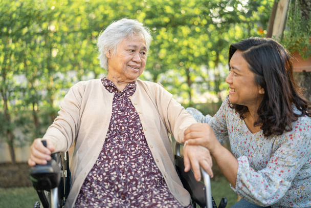 Помощь и уход Азиатская пожилая или пожилая старуха пациентка, сидящая на инвалидной коляске в парке в палате медсестер, здоровый сильный медицинский концепт. - Фото, изображение