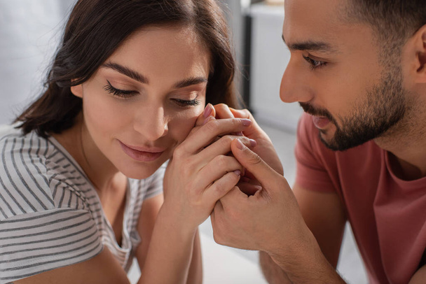 close up view of young man gently touching hands near face of girlfriend at home - Photo, Image