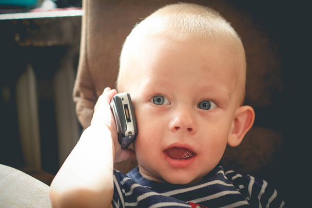 Годовой мальчик звонит на мобильный телефон - Фото, изображение