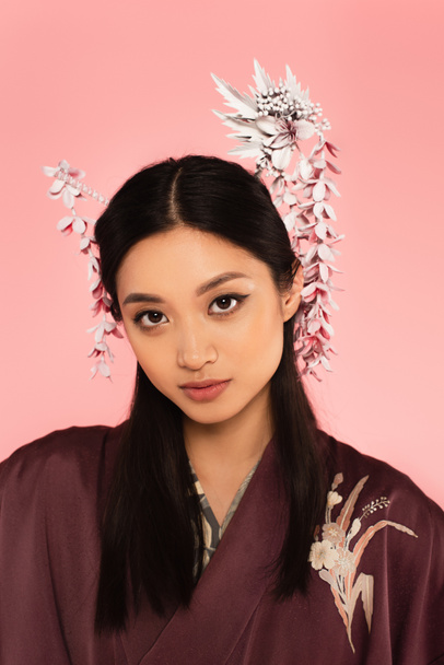 Young asian woman with traditional hairdo isolated on pink  - Zdjęcie, obraz