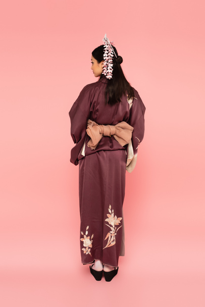 Side view of asian woman in traditional costume on pink background - Fotografie, Obrázek