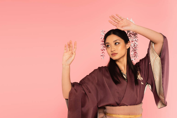 Junge Asiatin im Kimono und Kanzler im Haar isoliert auf rosa  - Foto, Bild