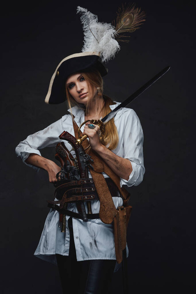 Studio záběr ženy korzár s šavlí a zbraněmi - Fotografie, Obrázek