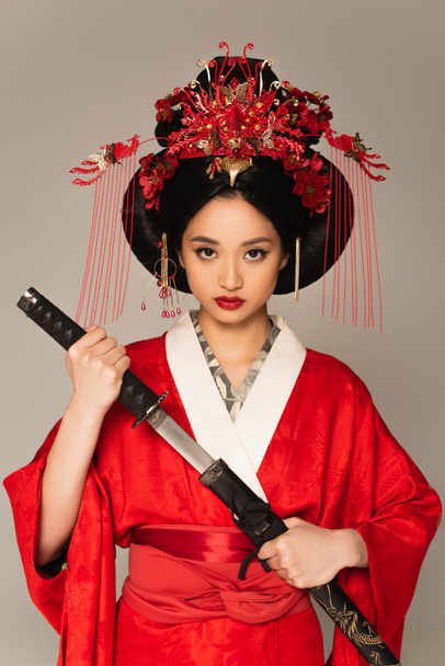 Asian woman in national clothes holding weapon isolated on grey  - Фото, зображення