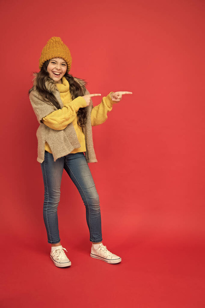 kid in knitwear accessory apparel pointing finger, copy space. enjoy weather and softness. cozy sweater. autumn season fashion. teenage girl in soft garment. warm clothing trends. childhood happiness - Foto, Imagem