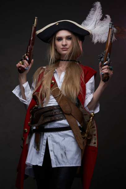 Женщина-бандит с трикорном в костюме и двумя пистолетами - Фото, изображение