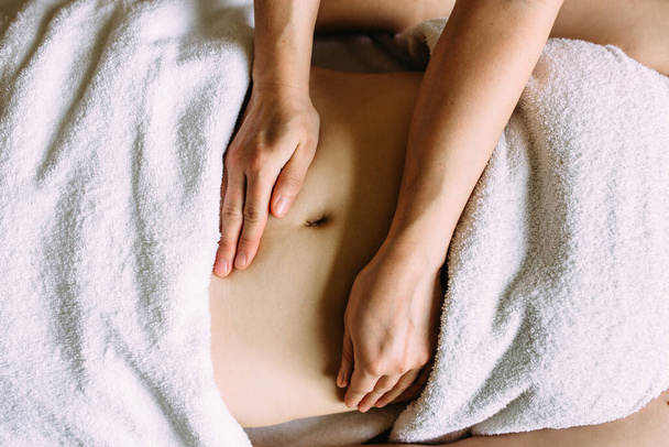 Le masseur donne un massage au ventre féminin au spa. - Photo, image