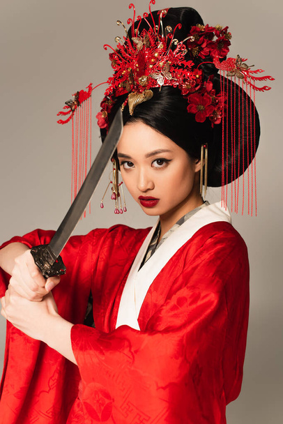 Japanese woman with national hairdo holding sword isolated on grey  - Foto, Imagem