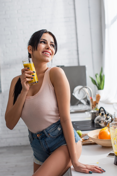 happy young woman holding glass with mixed smoothie  - Foto, afbeelding