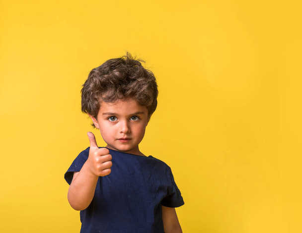 happy child and gestures concept. picture of smart boy showing thumbs up. Sign of like. Kindergarten or school student. Stylish pupil is ready to go to school. - Foto, Imagen