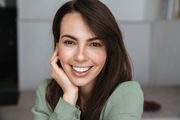Cheerful beautiful woman smiling and looking at camera indoors - Фото, зображення