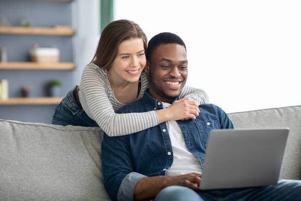 Πορτρέτο της αγάπης διαφυλετικό ζευγάρι χρησιμοποιώντας φορητό υπολογιστή μαζί στο σπίτι - Φωτογραφία, εικόνα