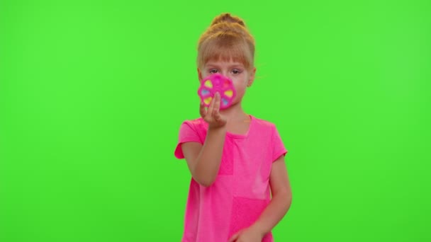 Девушка играет в прялки с поп-это сенсорная антистрессовая игрушка в парке, снятие стресса тревоги, хрома ключ - Кадры, видео