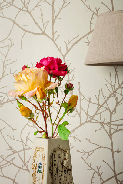 Fotografia de uma rosa vermelha e uma rosa amarela em uma vase.It marrom é uma foto que visa mostrar a naturalidade de um buquê de flores em uma casa.A foto é tirada em formato vertical. - Foto, Imagem