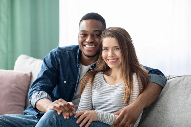 Portré mosolygó fiatal multikulturális pár pózol otthon beltéri - Fotó, kép
