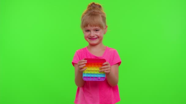 Dítě hrát s pop to smyslové hračky, dívka lisuje na rozmačkaný silikonové dotykové obrazovky bubliny - Záběry, video