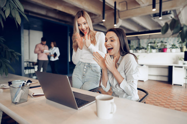 Two young happy businesswomen celebrating project success in office - Φωτογραφία, εικόνα