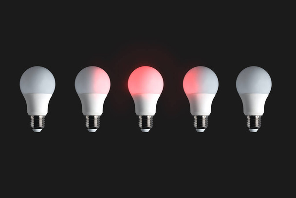 黒い背景に赤い光る電球。アイデア、創造性、エネルギー、発明、革新、リーダーシップの概念. - 写真・画像