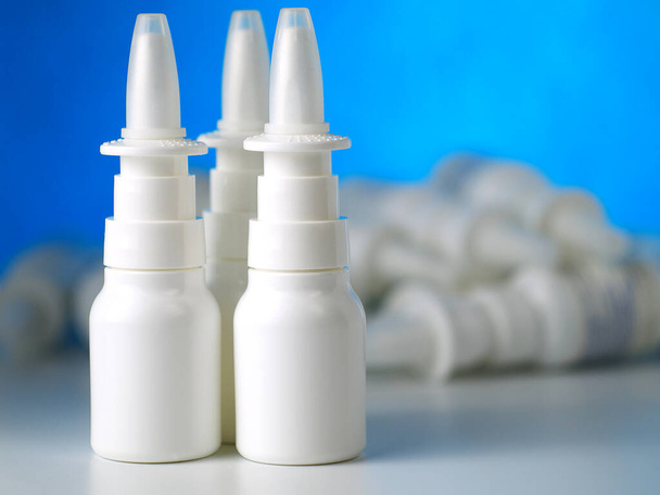three nasal spray bottles in front of other bottles heap, shallow depth of field - Φωτογραφία, εικόνα