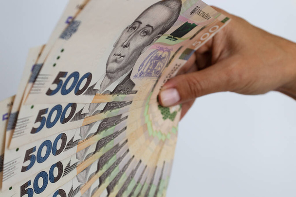 Ukrainian money in a female hand. Ukrainian 500 banknotes closeup. - Foto, afbeelding