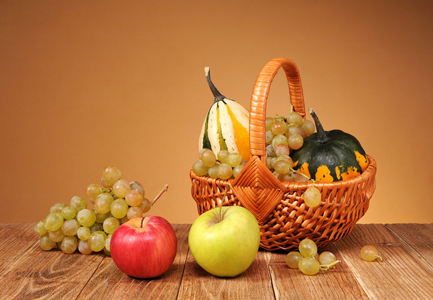 Omenat, viinirypäleet ja koristekurpitsat pajukoreissa
 - Valokuva, kuva
