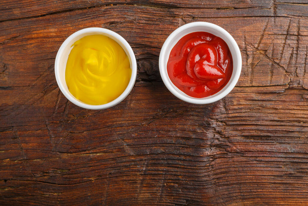 Sauce boats with cheese sauce and ketchup on a wooden table. Save a place. Horizontal photo - Foto, Imagen