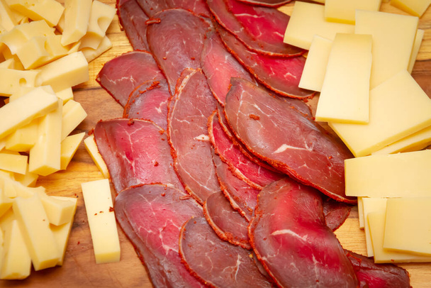 Zimno krojone mięso i ser na drewnianej tablicy zbliżenie. Zdjęcie żywności. - Zdjęcie, obraz