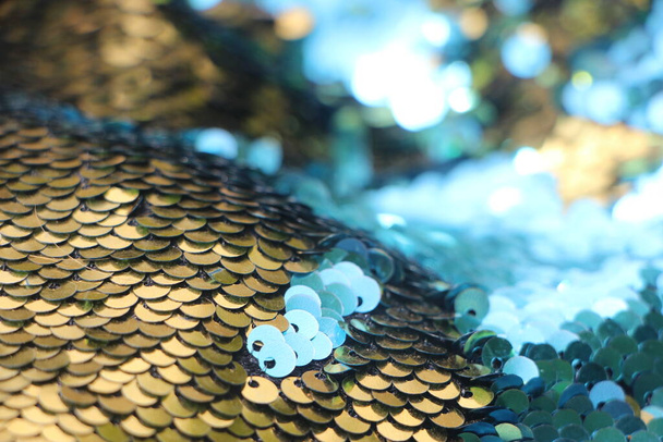 Texture pailletée abstraite de vacances avec lumières clignotantes. Paillettes de tissu en fond bleu et or. - Photo, image