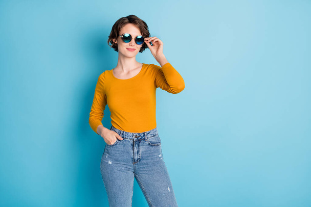 Photo of optimistic brunette lady touch spectacles wear yellow shirt isolated in vivid blue color background - Photo, Image