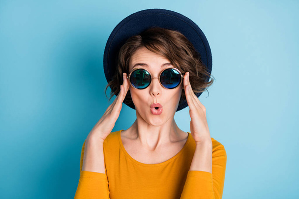 Photo portrait of amazed shocked woman in sunglass wearing shirt headwear isolated on bright blue color background - Fotó, kép