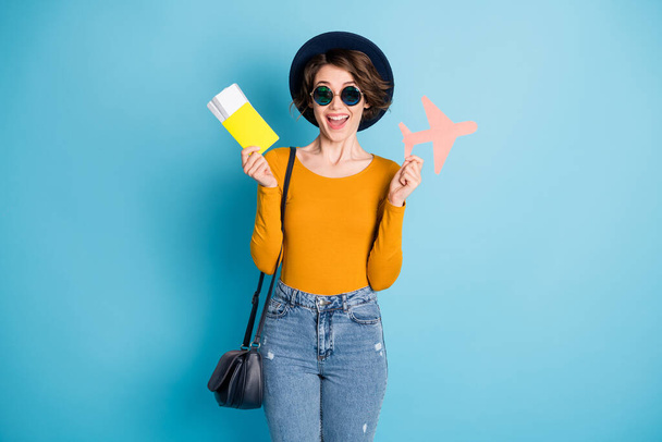Photo of impressed brunette lady hold plane ticket wear cap spectacles bag shirt isolated in vivid blue color background - Φωτογραφία, εικόνα