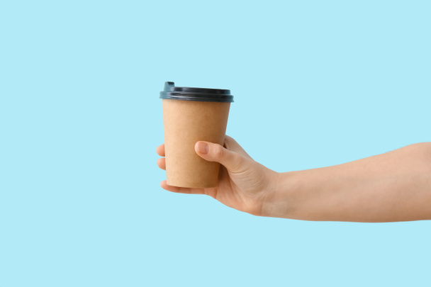 Woman with takeaway cup for coffee on color background - Photo, Image