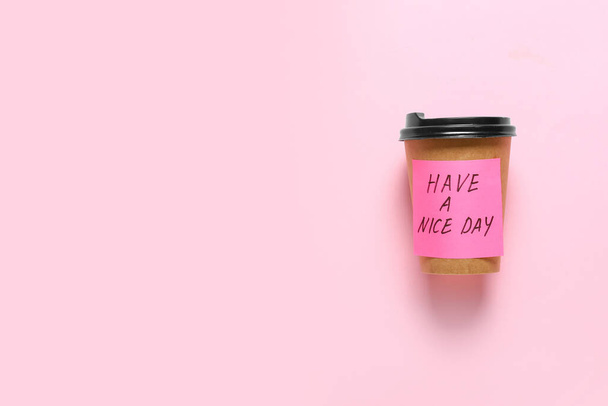 Taça Takeaway para café e adesivo nota com texto ter um bom dia no fundo de cor - Foto, Imagem