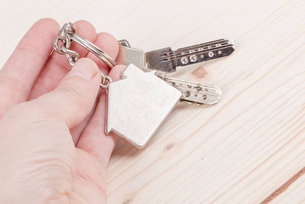 hand holding keys with house shaped keyring with copy space - Fotografie, Obrázek